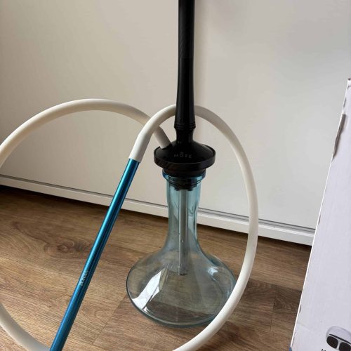 Shisha mit Glasbowl, Schlauch und Kopf, auf Holzboden.
