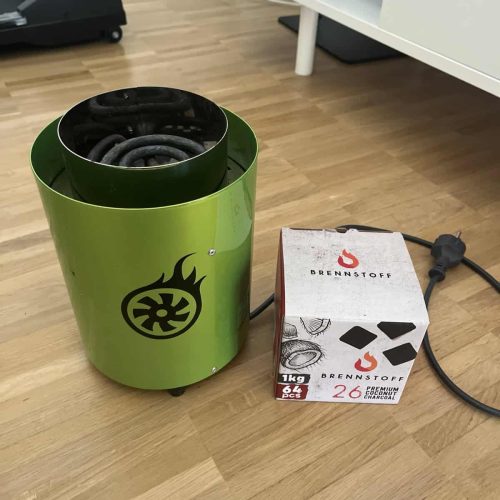 Grünes Heizgerät für Shisha mit Brennstoffbox daneben.