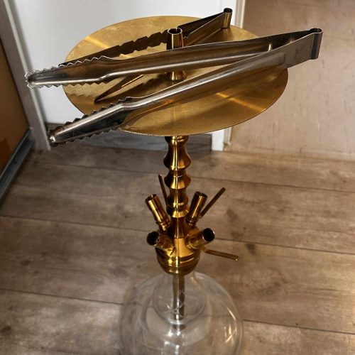 Shisha-Tabakständer mit goldener Glasbowl und Metallzubehör.
