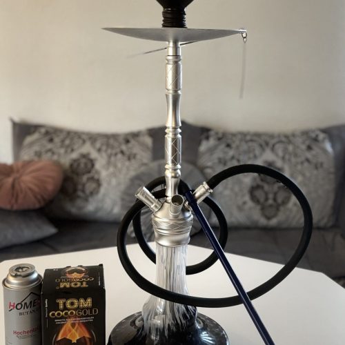Rauchsäule mit Shisha, Tabak und Feuerzeug auf Tisch, für Raucherlebnis.