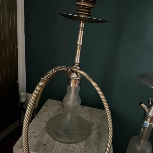 Moderne Shisha mit Metall- und Glasdesign auf Holztisch.