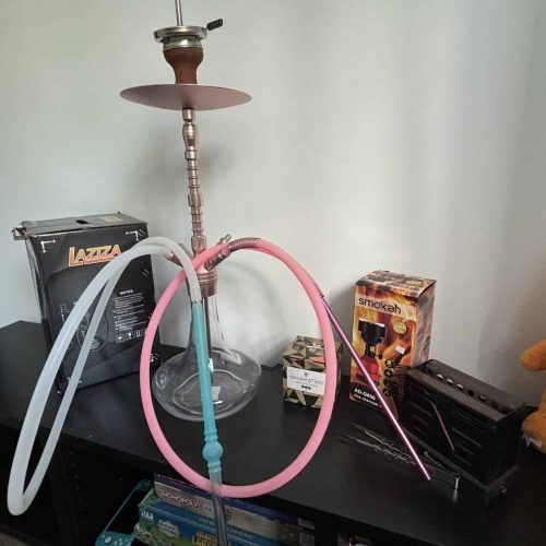 Shisha mit Silikonschlauch und Zubehör auf Tisch.