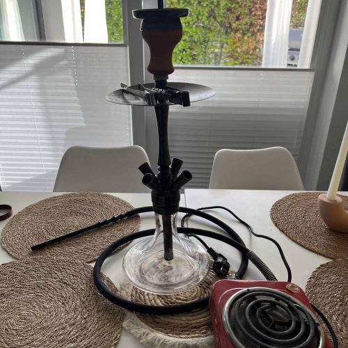 Raucherset für Shisha mit Heizplatte, Schlauch und Zubehör auf Esstisch.