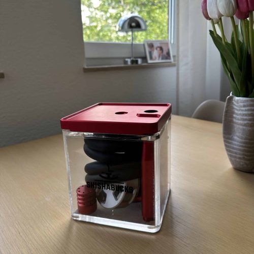 Shisha-Head in transparent Aufbewahrungsbox auf Tisch.