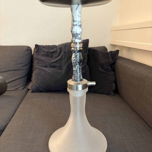 Moderne Shisha mit Glasaufsatz auf Couch im Wohnzimmer.