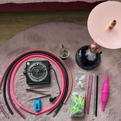 Verschiedene Shisha-Teile und Zubehör auf einem Teppich.