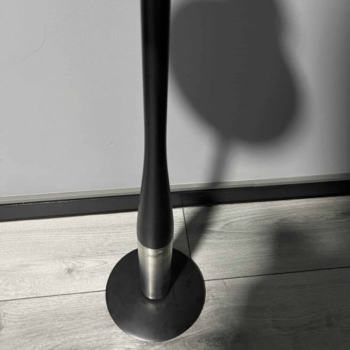 Schirmständer mit schwarzem Metallstab und runder Basis, ideal für den Innenbereich.