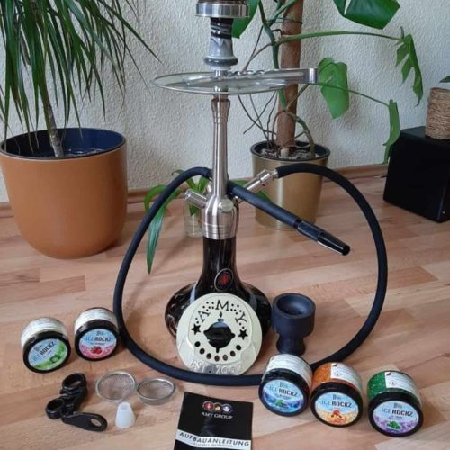 Shisha mit Rauchsäule, Tabak und Zubehör auf Holzboden.