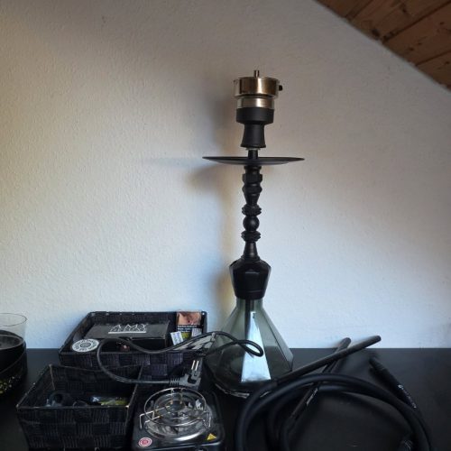 Shisha-Zubehör mit Glasbowl, Schlauch und Kohlezange.