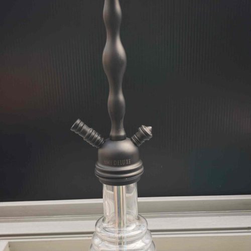 Schwarze Shisha mit Glasbowl und Metallstamm auf Tisch.