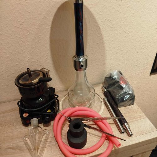 Raucherset mit Shisha, Kohle, Schlauch und Zubehör auf Tisch.