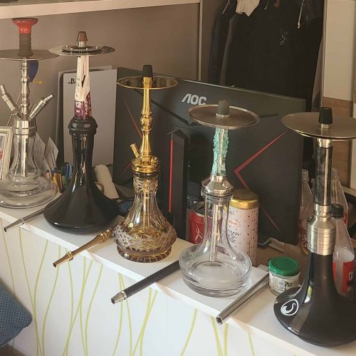 Verschiedene Shisha-Köpfe und Rauchschalen auf einem Tisch, bereit für den Gebrauch.