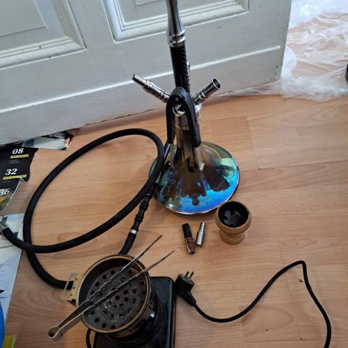Moderne Shisha mit Glasbowl, Schlauch und Tabakzubehör.