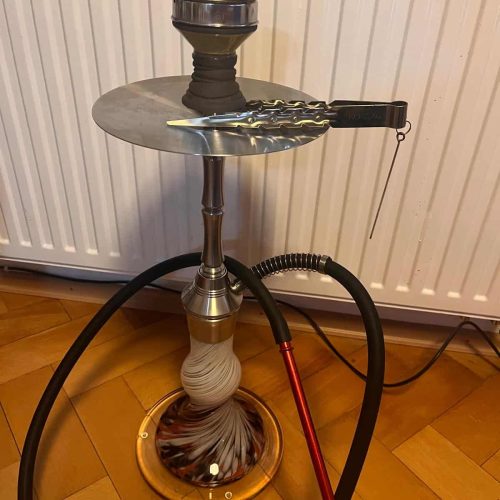 Rauchsäule mit Shisha, Schlauch und Messer auf einem Holzboden.