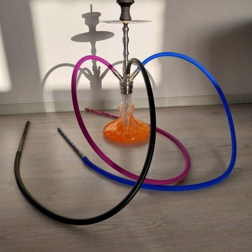 Bunte Shisha mit drei Schläuchen auf Holzboden, Rauch steigt auf.