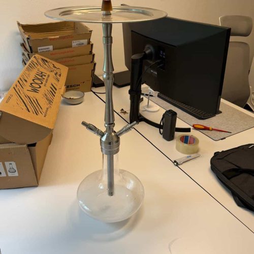 Rauchsäule mit Glasbasis, Metallrohr und Ablage für Shisha-Accessoires.