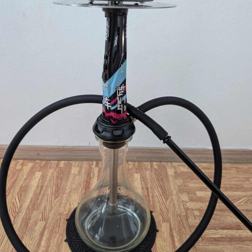 Moderne Shisha mit Glasbasis, Schlauch und Metallaufsatz, auf Holzboden.