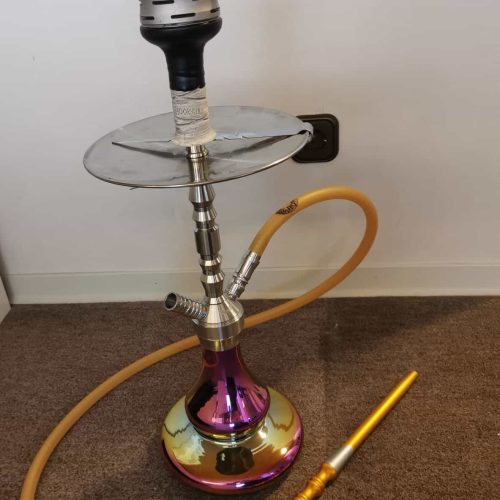 Shisha mit Glasbowl, Schlauch und Heizsystem auf Boden.