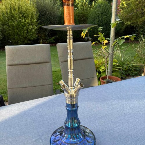 Blaue Shisha mit Glasbowl auf Tisch im Garten.