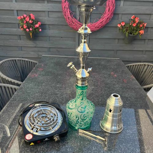 Shisha-Kamin mit Glasbowl, Kohleanzünder und Zubehör auf Tisch.