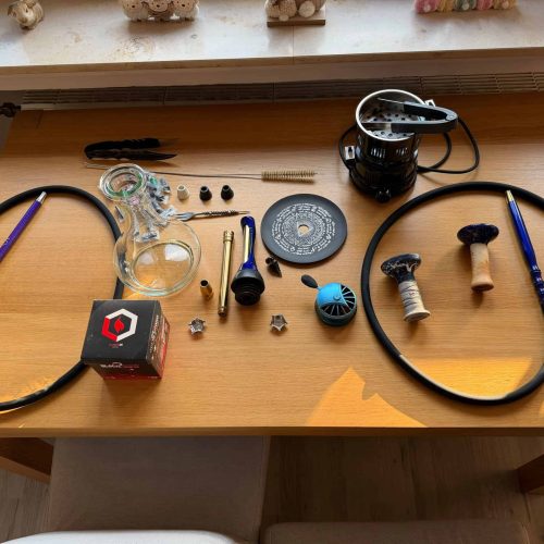 Verschiedene Shisha-Teile und Zubehör auf einem Tisch.