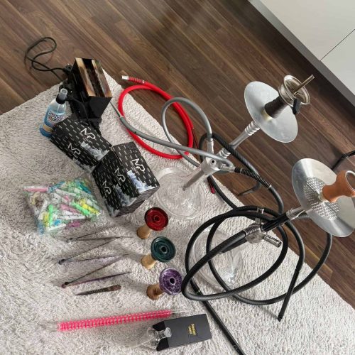 Verschiedene Shisha Teile und Glasbowl auf Teppich.