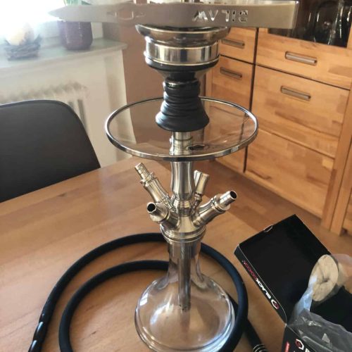 Rauchsäule mit Shisha-Kopf, Schlauch und Zubehör auf Holztisch. Perfekt für gemütliche Abende.