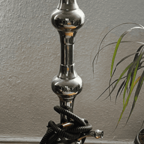 Rauchende Wasserpfeife auf Holzfußboden, stilvolle Shisha mit Glasbasis.
