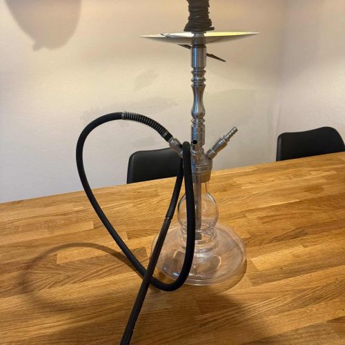 Rauchende Wasserpfeife auf einem Holztisch, ideal für gemütliche Abende.