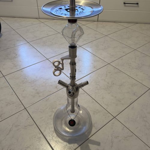 Rauchsäule mit Wasserpfeife, Metallplatte und Zubehör im Innenraum.