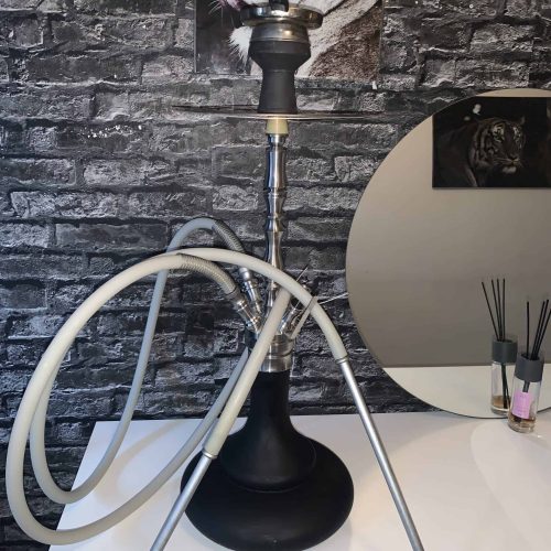 Rauchsäule mit Shisha auf weißem Tisch, dekorative Tierbilder im Hintergrund.