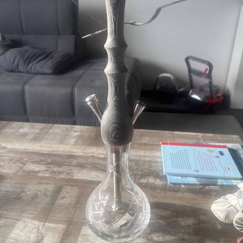 Dekorative Shisha mit Glasbasis und Metallrohr.