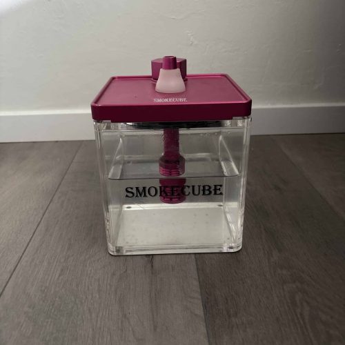 Klare Aufbewahrungsbox für Rauchzubehör mit pinkem Deckel.