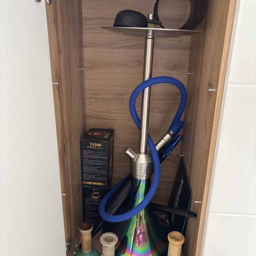Bunte Shisha mit Glasbowl und Zubehör im Holzschrank.