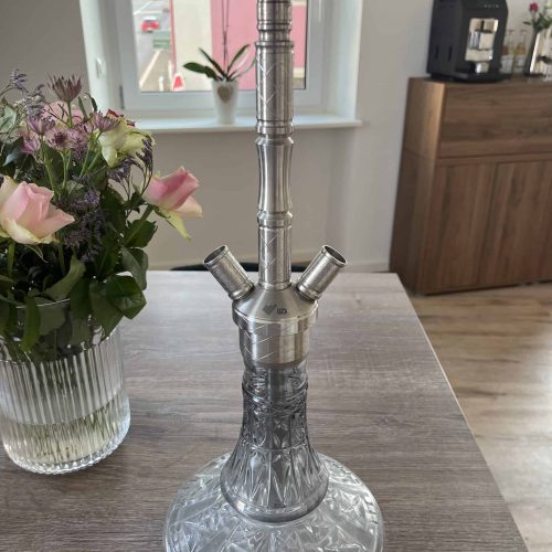 Silberne Shisha mit Glasbowl auf Holztisch, Fenster im Hintergrund.
