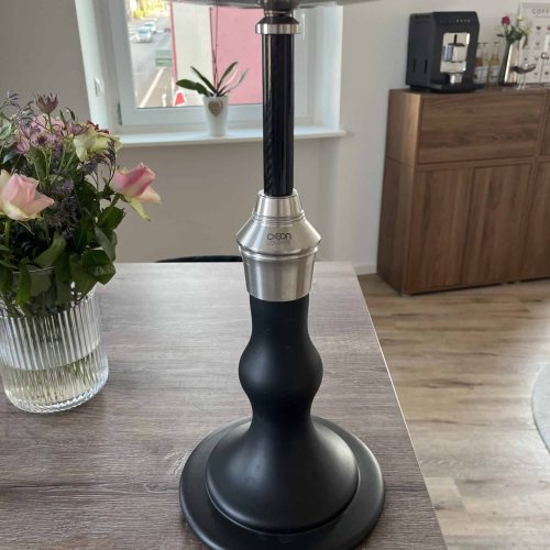 Schwarze Shisha mit Metall- und Glasbowl auf Holztisch.