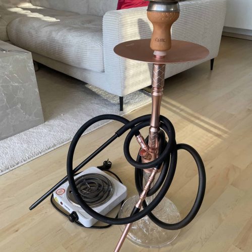 Alte Wasserpfeife mit Schlauch und Kohlehalter, ideal für Shisha-Liebhaber.