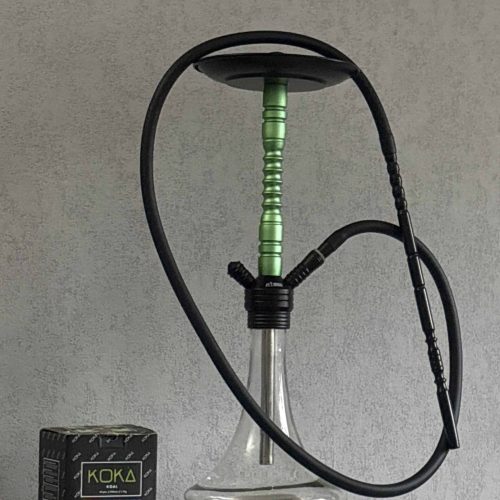 Shisha-Kopf mit Schlauch und Glasbowl auf weißem Tisch.