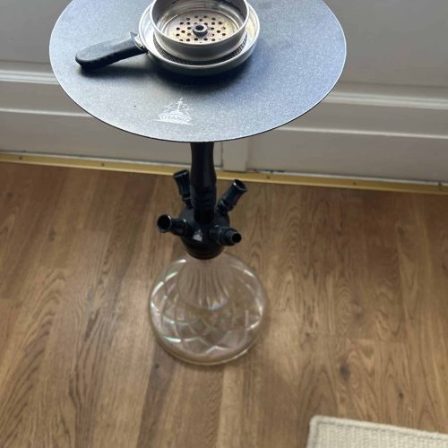 Shisha-Glasbowl auf einem schwarzen Tablett, auf einem Wasserpfeifenständer.