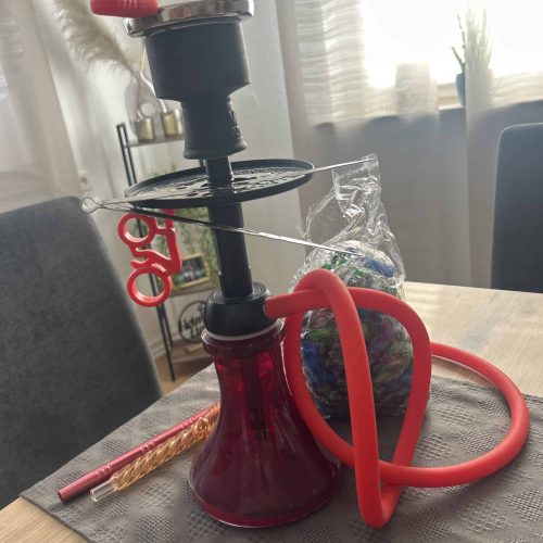 Shisha mit roter Glasbowl, Silikonschlauch und Zubehör.