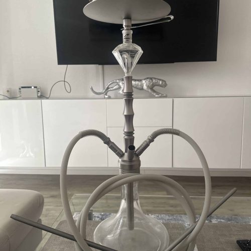Moderne Shisha mit Wasserpfeife und Zubehör, auf einem Tisch.