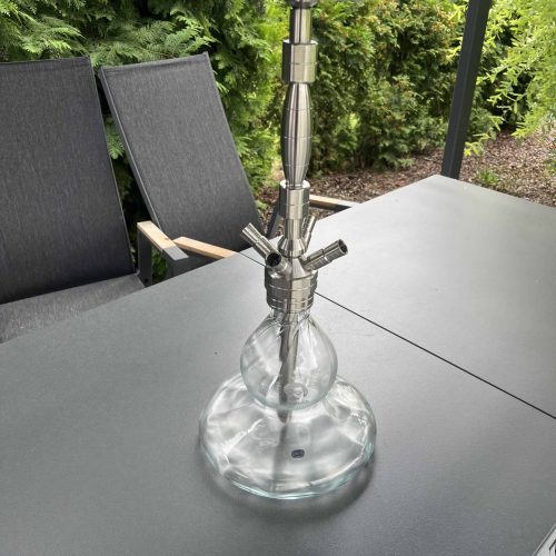Moderne Shisha mit Glasbowl auf Tisch im Garten.