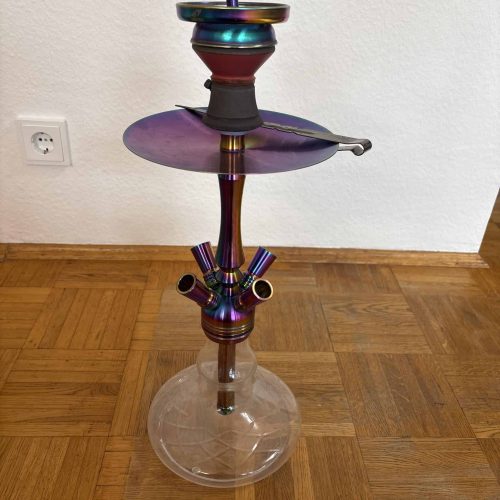 Wasserpfeife mit buntem, reflektierendem Finish, auf Holzboden stehend.