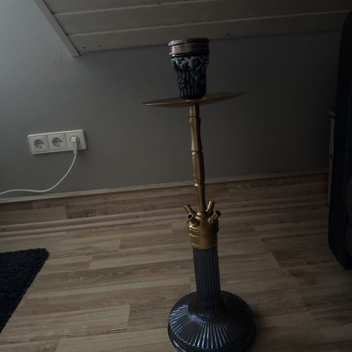 Rauch-Hookah mit goldener Ablage und blauer Basis, auf Holzboden.