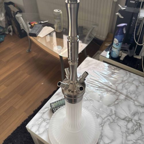 Moderne Shisha-Rauchsäule mit Glasaufsatz auf Tisch.
