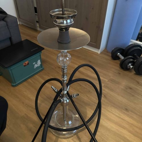 Rauch-Hookah mit Metall- und Glasbestandteilen, Zubehör im Raum.
