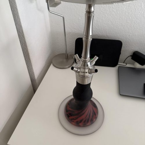 Moderne Shisha mit Metall- und Glasdesign auf weißem Tisch.