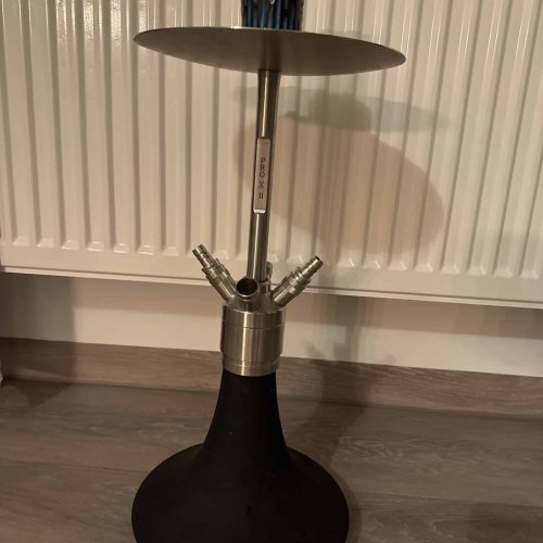 Rauchende Shisha auf einem schwarzen Standfuß mit Metallaufsatz und Deckel.