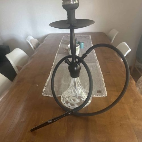 Shisha mit Glasbowl, Schlauch und Kopf auf Esstisch.