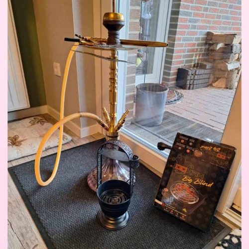 Rauch-Hookah mit Wasserpfeife, Schlauch und Tabak auf Tisch.